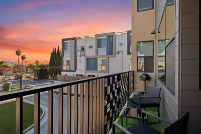 a balcony of a building with a sunset in the background at Stylish 2 Bedroom King Bed EVCharger Pet-Friendly Balcony in San Diego