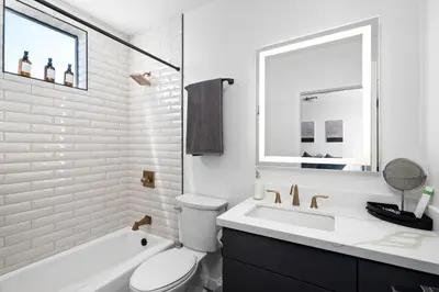 a white bathroom with a toilet and a sink at Stylish 2 Bedroom King Bed EVCharger Pet-Friendly Balcony in San Diego