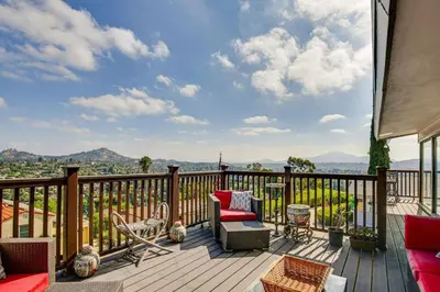 a deck with a couch and chairs on a balcony at Amazing Views with massive pool Total Oasis in La Mesa