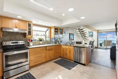 a kitchen with wooden cabinets and stainless steel appliances at Massive 5 bedroom overlooking the water-STR14-0105 in Dana Point