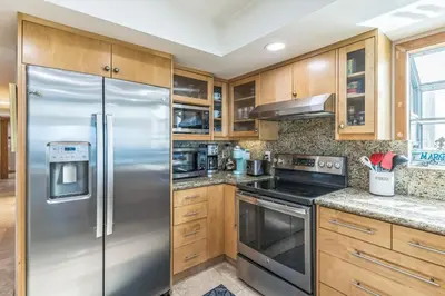 a kitchen with a stainless steel refrigerator and wooden cabinets at Massive 5 bedroom overlooking the water-STR14-0105 in Dana Point
