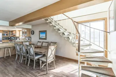 a dining room with a table and chairs and a spiral staircase at Massive 5 bedroom overlooking the water-STR14-0105 in Dana Point