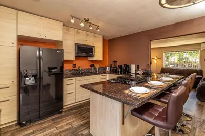 a kitchen with a large island with a black refrigerator at Giraffe House in Chula Vista