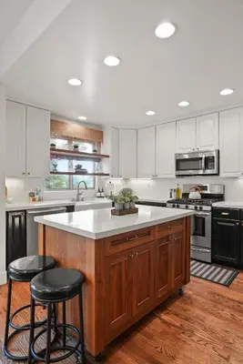 a kitchen with white cabinets and a large island with stools at Village Vistas - Walk to Beach and LJ Village, AC, Spa in San Diego