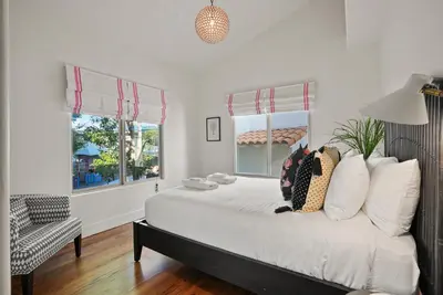 a bedroom with a bed and two windows at Village Vistas - Walk to Beach and LJ Village, AC, Spa in San Diego