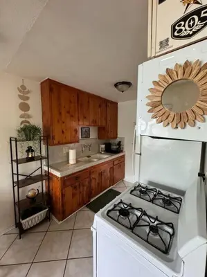 a kitchen with a stove and a white refrigerator at Boho Chic Loft Little Italy Walk Everywhere in San Diego