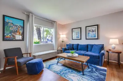 a living room with a blue couch and a table at Tidal Wave 1 in San Diego