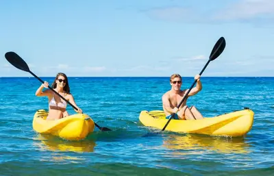 a man and woman in kayaks in the ocean at Tidal Wave 1 in San Diego