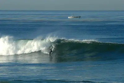 a person riding a wave on a surfboard in the ocean at Tidal Wave 1 in San Diego