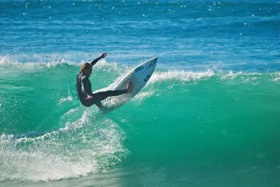 a man riding a wave on a surfboard in the ocean at Tidal Wave 1 in San Diego