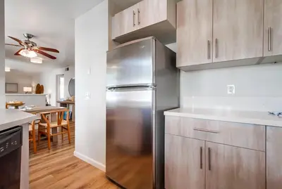 a stainless steel refrigerator in a kitchen with a table at Local Gem 1 in San Diego