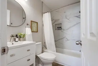a white bathroom with a toilet and a sink at Local Gem 1 in San Diego