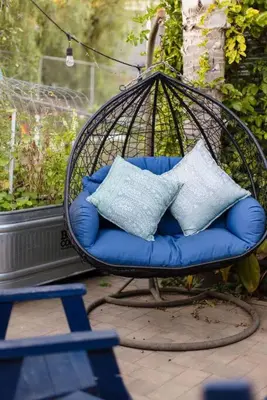 a swing chair with two pillows in a yard at Leucadia Beach House - 4 Mins to Moonlight! in Encinitas