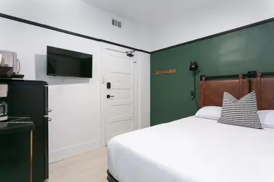 a bedroom with a bed and a flat screen tv at La Ventana Hotel in San Diego