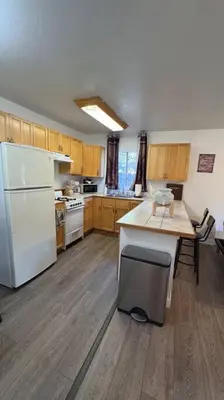 a kitchen with a white refrigerator and a table at Cozy Mountain Guest house in Pine Valley