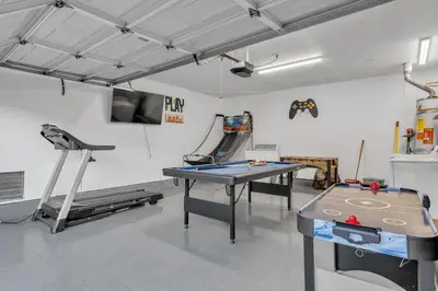 a room with a ping pong table and a simulator at Hilltop Home Hot Tub BBQ Game Room Self Check-In in Poway