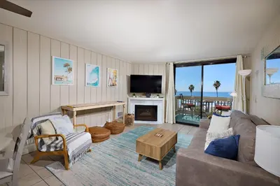 a living room with a couch and a tv at Oceanside Beach Condos in Oceanside