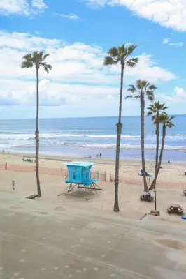 a picnic table on the beach with palm trees at Oceanside Beach Condos in Oceanside
