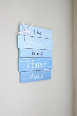 a stack of books with a sign that reads the beach is my happy place at Oceanside Beach Condos in Oceanside