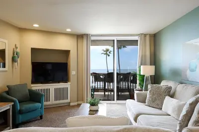 a living room with a couch and a television at Oceanside Beach Condos in Oceanside