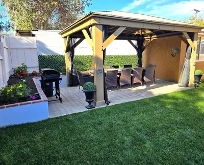 a pavilion with chairs and a grill in a yard at San Diego Fun-Gameroom & Gazebo-Centrally Located! in San Diego