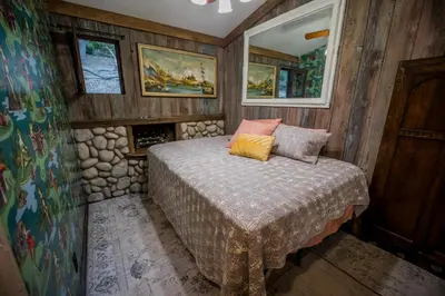 a bedroom with a bed in a wooden room at Historic Farmhouse on 5 Peaceful Acres with Ancient Oaks & Creek above Temecula in Temecula