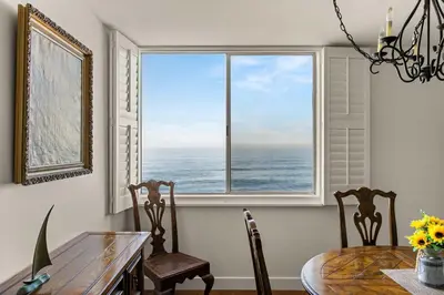 a dining room with a view of the ocean from a window at Waterfront Condo Unmatched Views and Prime Location in San Diego