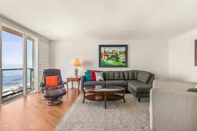 a living room with a couch and a table and chairs at Waterfront Condo Unmatched Views and Prime Location in San Diego