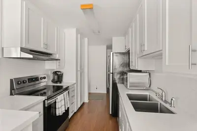 a kitchen with white cabinets and stainless steel appliances at Waterfront Condo Unmatched Views and Prime Location in San Diego