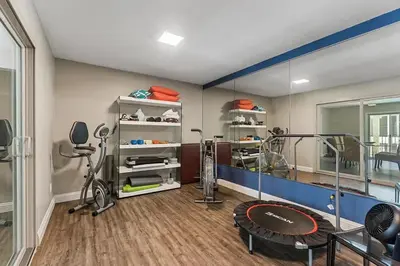 a room with a gym with a bike and a mirror at Waterfront Condo Unmatched Views and Prime Location in San Diego