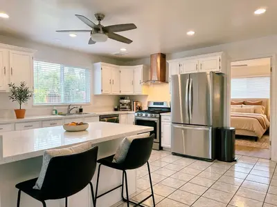 a kitchen with a stainless steel refrigerator and a bed at Pet friendly Spacious 3Bed with HUGE Back Yard in San Diego