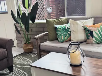 a living room with couches and a table with a candle at Comfortable 2Bed in Duplex with private Sunroom in San Diego