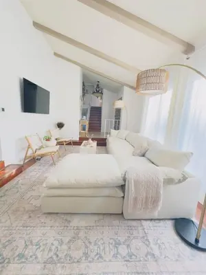 a living room with a white couch and a tv at Del Mar Coastal Haven in San Diego