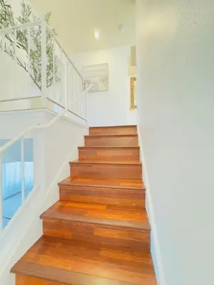 a staircase in a house with wooden floors and white walls at Del Mar Coastal Haven in San Diego