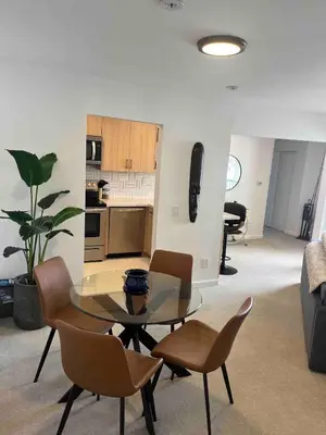 a living room with a glass table and chairs at Penthouse at Pacific Beach Crystal Pier in San Diego