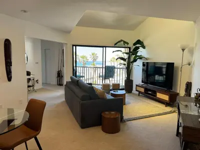 a living room with a couch and a flat screen tv at Penthouse at Pacific Beach Crystal Pier in San Diego