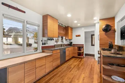a kitchen with wooden cabinets and a large window at Boho-Style Point Loma Retreat Large Outdoor Deck in San Diego