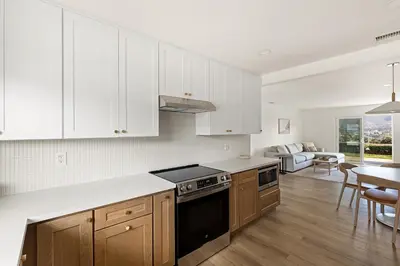 a kitchen with white cabinets and a stove top oven at Modern Escape w Mountain Views, Walk to Lake, Golf, Resort, Dining in San Marcos