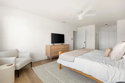 a bedroom with a bed and a tv and a chair at Modern Escape w Mountain Views, Walk to Lake, Golf, Resort, Dining in San Marcos