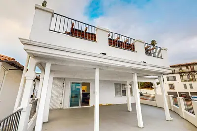 a white house with a balcony on top of it at Cozy Couples Escape! Walk to San Clemente Pier in San Clemente