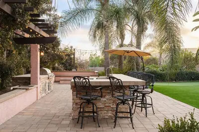 a patio with a table and chairs and an umbrella at Stunning Private Resort with Pool in San Marcos