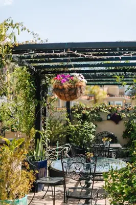 a patio with chairs and a basket of flowers at Laguna Cove Hotel in Laguna Beach