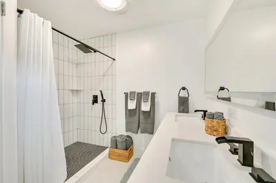 a white bathroom with a shower and a sink at House Kitsune - Steps to Beach in Oceanside