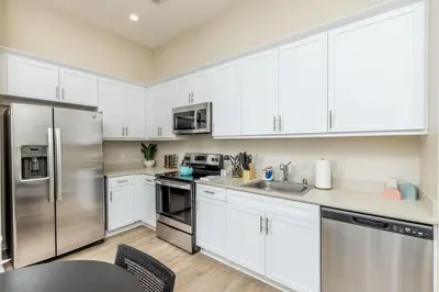 a kitchen with white cabinets and stainless steel appliances at Eclectic Fast Wi-Fi Parking Pets Bohemian in San Diego