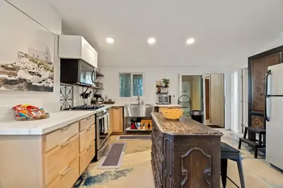 a large kitchen with white walls and wooden cabinets at Next to Downtown Huge yard with Parking in San Diego