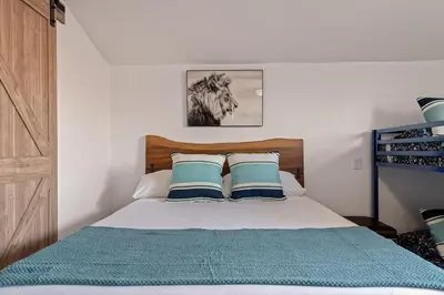 a bed with blue and white pillows in a bedroom at Next to Downtown Huge yard with Parking in San Diego