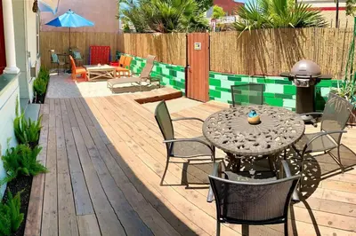 a patio with a table and chairs on a wooden deck at Historic 1910 House near downtown in San Diego