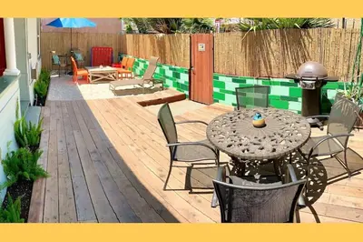 a patio with a table and chairs on a wooden deck at Historic 1910 House near downtown in San Diego