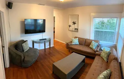 a living room with a couch and a tv at Historic 1910 House near downtown in San Diego