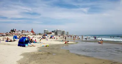 a group of people on a beach with the ocean at Entire Private Home with 3 Bedrooms, Gated Yard, Parking, King Bed, Available Now in Spring Valley